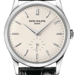Patek Philippe Genève wristwatch with beige dial, baton hour markers, small seconds subdial at 6 o'clock, stainless steel case and black leather strap