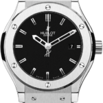 Hublot Geneve stainless steel wristwatch with a black dial and date window at 3 o'clock, on a textured strap.