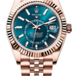 Rose gold Rolex Sky-Dweller watch with a blue dial, fluted bezel, and a rose-gold bracelet, showing the date at 3 o'clock by magnified window.