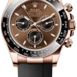 Rose gold Rolex Daytona watch with black ceramic bezel and dark brown dial, attached to a black rubber strap.