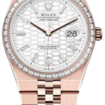 Rose-gold Rolex Oyster Perpetual Land-Dweller watch with a diamond-set bezel and white patterned dial showing date at 3 o'clock.