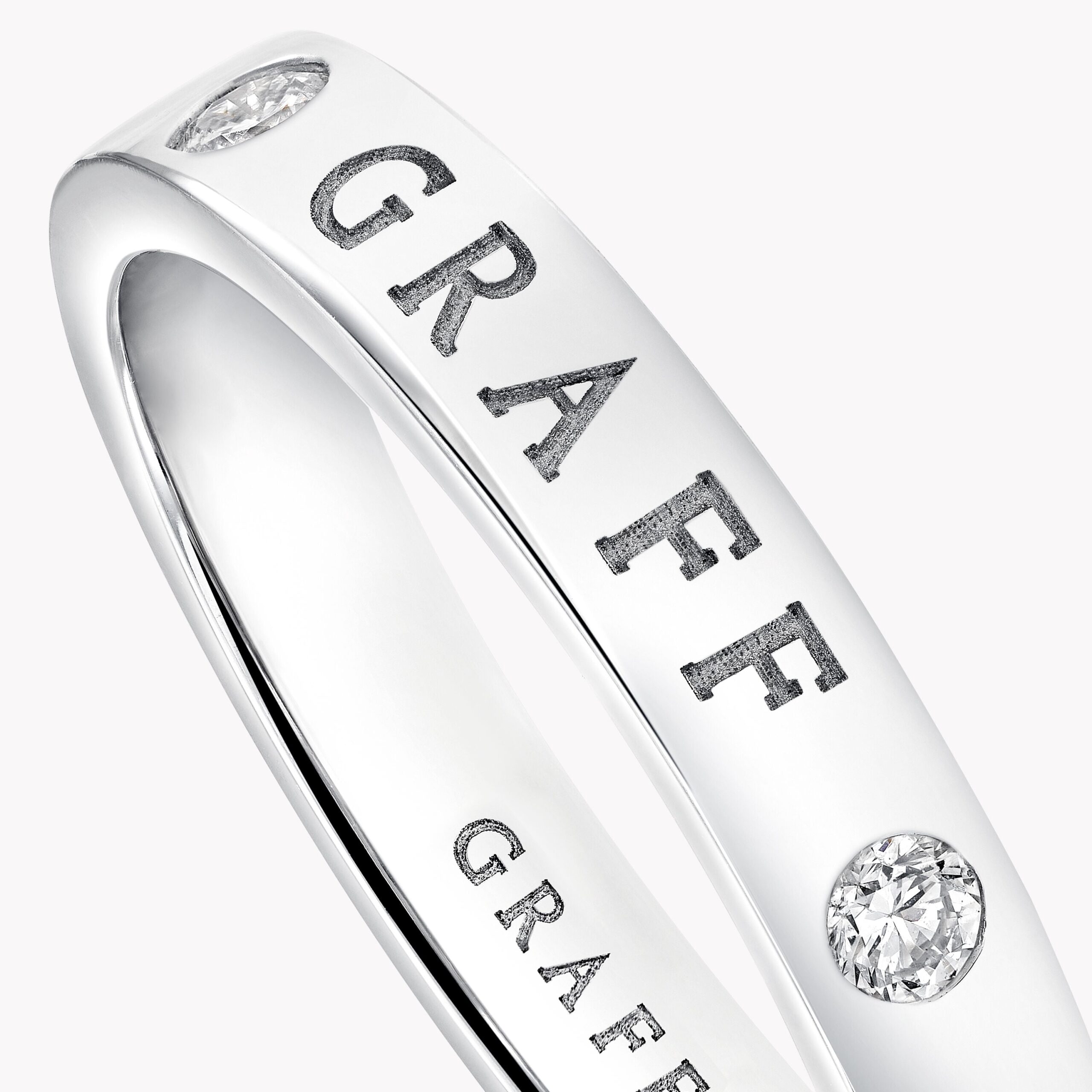Close-up of a silver ring with a diamond setting on a curved band.