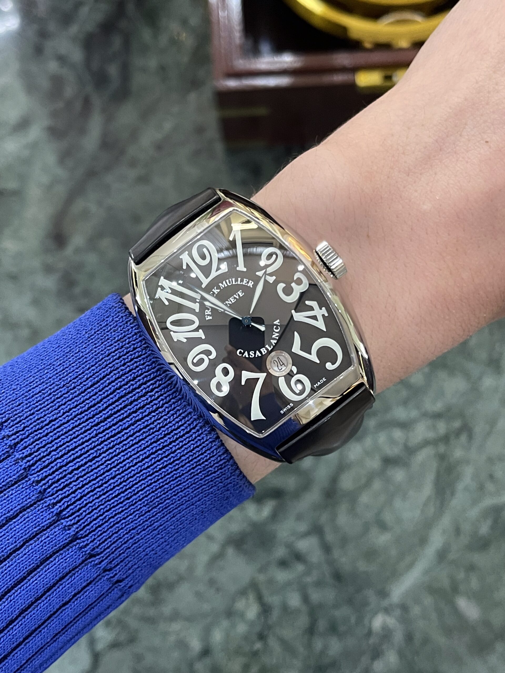 Wristwatch on a blue-sleeved arm: a black rectangular Franck Muller Casablanca with large white numerals