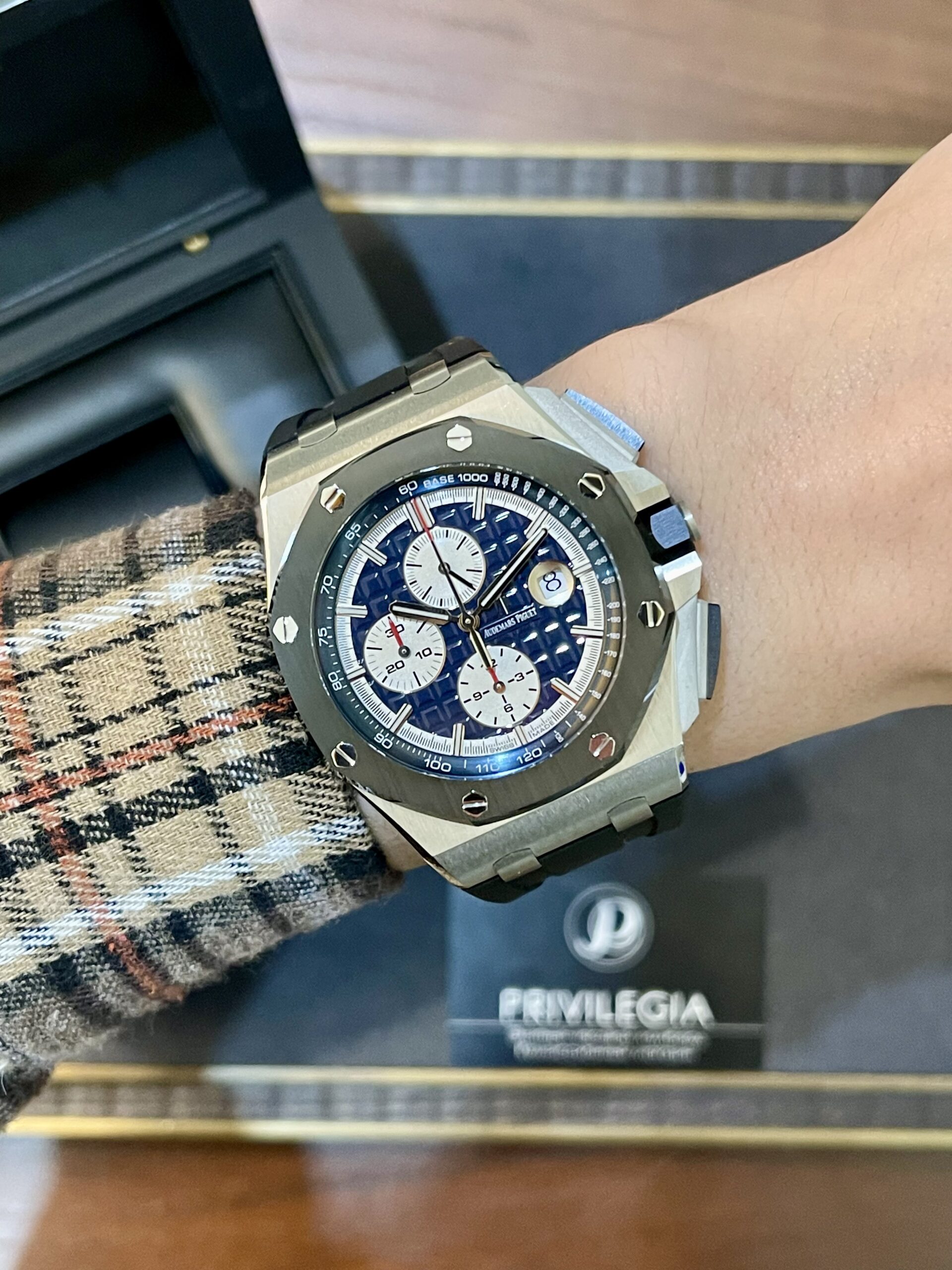 Wristwatch with a blue dial and white subdials on a metal bracelet, featuring an octagonal bezel with screws.