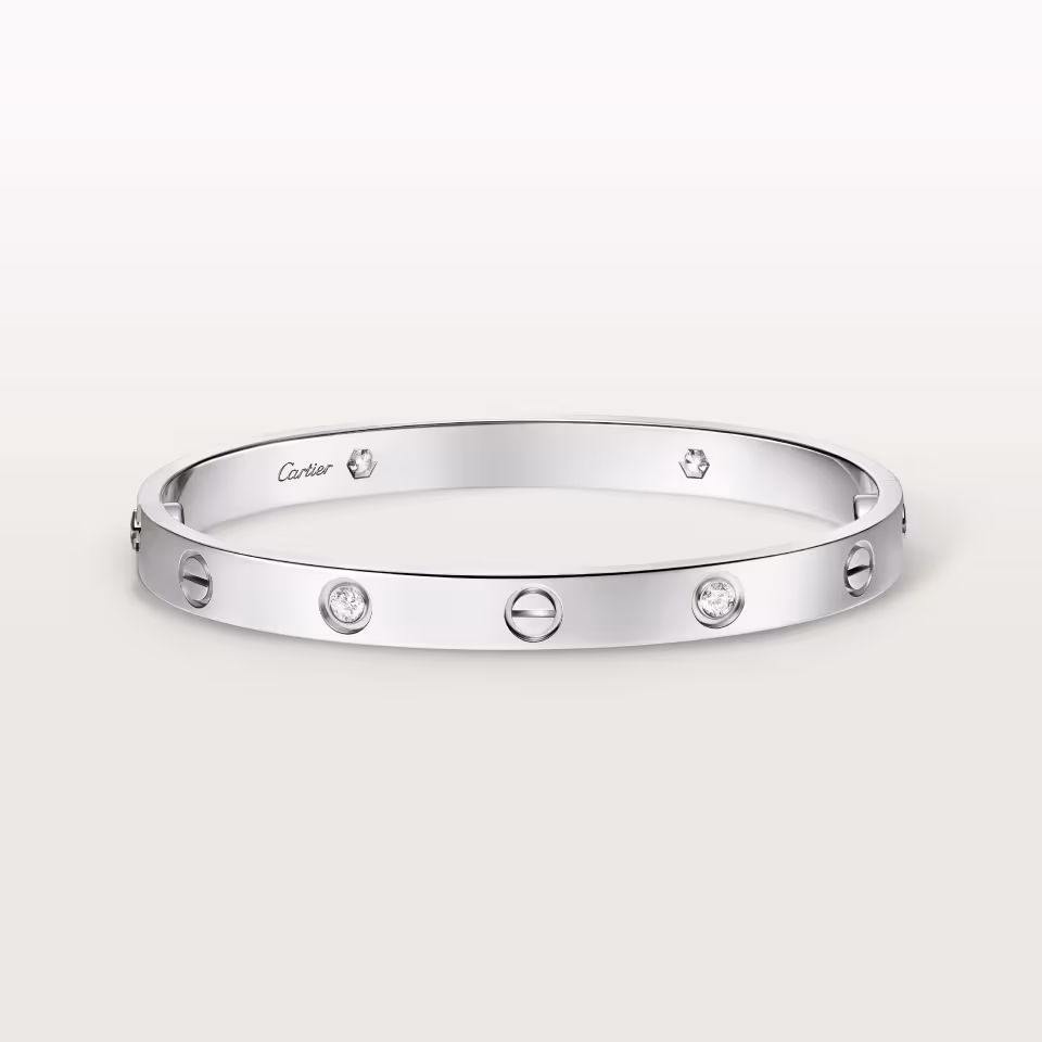 Cartier silver bracelet with evenly spaced round diamonds on a white background, polished and elegant.