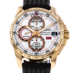 Gold-tone chronograph watch with white dial, multiple subdials, and a black textured strap.