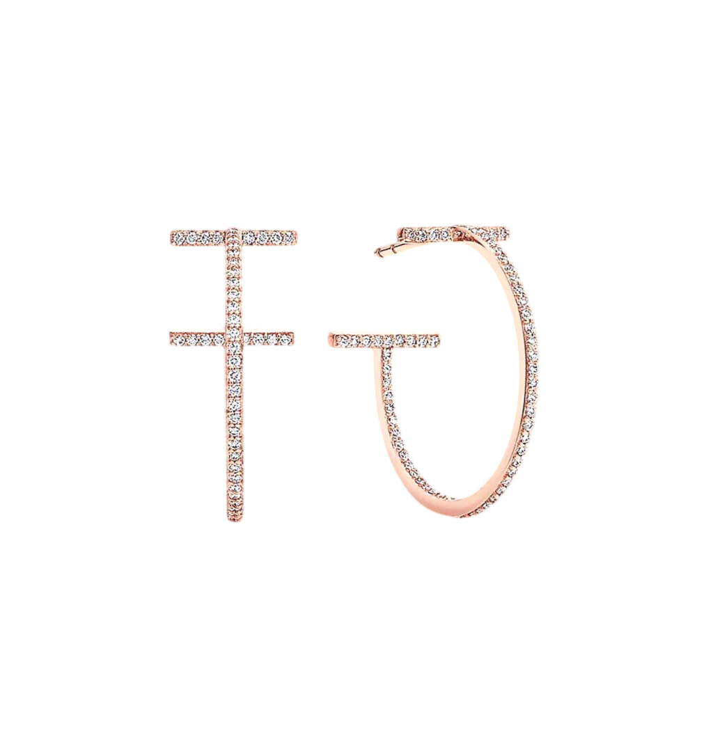 Rose-gold diamond-studded letter F beside a diamond-encrusted hoop earring on a black background
