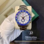 Stainless steel Rolex wristwatch with blue bezel reading YACHT-MASTER II, displayed on a beige cushion box.