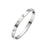 Silver Cartier Love-style bracelet: curved silver bangle with round diamonds set along the band against a black background