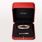 Cartier rose-gold Love bracelet with screw motifs and diamonds in a red presentation box with a small tool beside it.