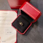 Cartier jewelry box with a gold ring displayed in a red accompanying case and certificate nearby